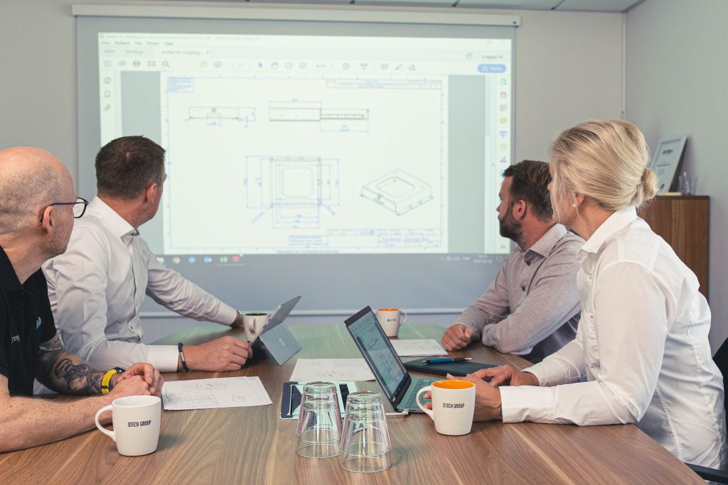 Projektmöte mellan ingenjörer kring ritning och dator