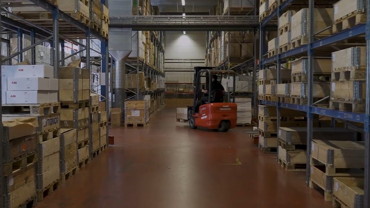 Truck kör i Qtechs lager i Anderstorp mellan pallställage med ordnade lastpallar